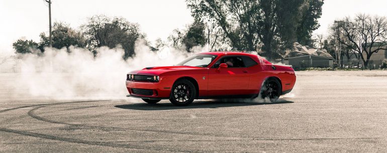 red coupe drifting on asphalt road